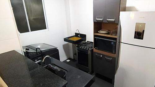 een kleine keuken met een koelkast en een fornuis bij Apto Executivo Ravena in Campo Grande