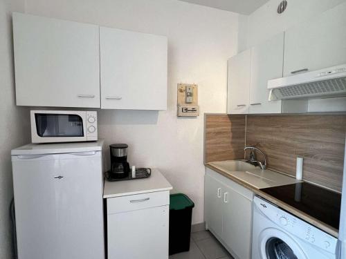 Il comprend une petite cuisine équipée d'un réfrigérateur blanc et d'un four micro-ondes. dans l'établissement Studio près de la plage, cabine, parking privatif, 4 pers, 1er étage, Valras-Plage - FR-1-701-2, à Valras-Plage