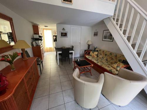 un salon avec un canapé et un escalier dans l'établissement Pavillon 4 pers. avec piscine, terrasse, jardin, proche plage et commerces, Valras-Plage - FR-1-701-5, à Valras-Plage