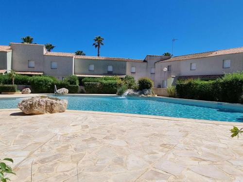 une piscine devant un immeuble dans l'établissement Pavillon Climatisé 2P Mezzanine avec 2 Terrasses et Piscine, à 650m de la Plage - 6 Pers - FR-1-701-4, à Valras-Plage