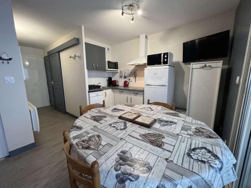 une cuisine avec une table recouverte d'une nappe dans l'établissement T2 à Valras-Plage avec Terrasse, Parking Privé, 4 Pers., Proche Plage et Commerces - FR-1-701-19, à Valras-Plage