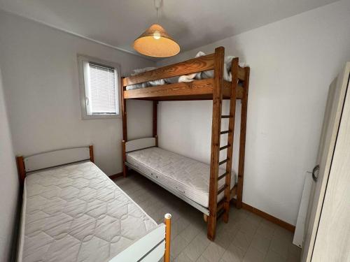 um quarto com 2 beliches e uma escada em Appartement Valras-Plage, 2 pièces, 4 personnes - FR-1-701-28 em Valras-Plage