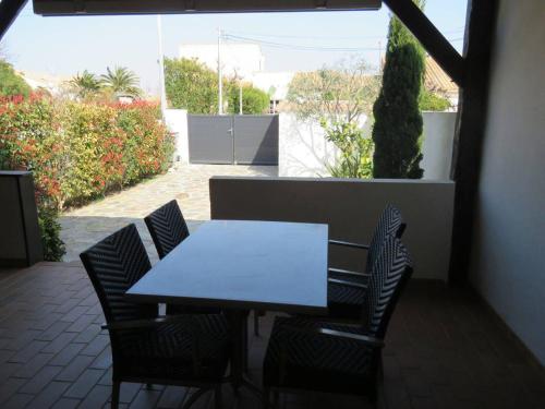 une table blanche et des chaises sur une terrasse dans l'établissement Maison avec Terrasse, BBQ, Cour, 700m Plage, 3 Pièces, 6 Personnes - FR-1-701-11, à Vendres