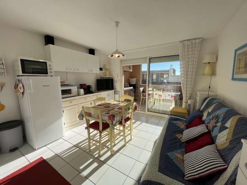 une cuisine et un salon avec un canapé et une table dans l'établissement Appartement T2 avec terrasse et garage, à 80m de la plage - FR-1-701-21, à Valras-Plage