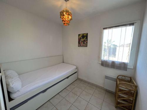 une petite chambre avec un lit et une fenêtre dans l'établissement Appartement T3 avec Piscine, Clim, Terrasse, Parking Privé – À 600m de la Plage, 6 Pers. - FR-1-701-14, à Valras-Plage