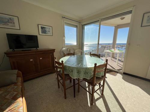 une salle à manger avec une table avec des chaises et une télévision dans l'établissement T3 avec terrasse, parking, proche plage et commerces - FR-1-701-16, à Valras-Plage