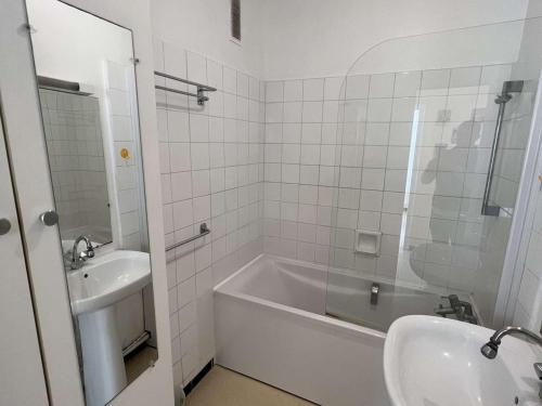 biała łazienka z wanną i umywalką w obiekcie T3 avec terrasse, parking, proche plage et commerces - FR-1-701-16 w mieście Valras-Plage