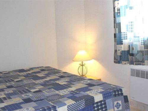 sypialnia z niebiesko-białym łóżkiem i lampą w obiekcie Maison cosy avec terrasse, 2 chambres, piscine partagée, proche plage et commerces, Gruissan - FR-1-229-832 w mieście Gruissan