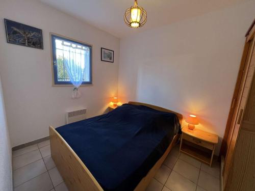 ein Schlafzimmer mit einem Bett, einem Fenster und zwei Lampen in der Unterkunft Appartement Valras-Plage, 3 pièces, 4 personnes - FR-1-701-27 in Valras-Plage
