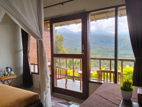 a bedroom with a door open to a balcony at Made Oka Homestay and Warung in Munduk