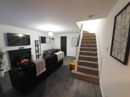 a living room with a staircase and a couch and a fireplace at Newly Refurbished Home in Bradley Stoke, near Cribbs Causeway, Bristol, for Long Stays, Group Stays, Contractors, Sleeps up to 7 guests, Free Parking!! in Bristol