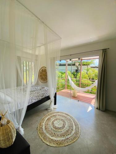 a bedroom with a canopy bed and a balcony at La Reserve Villa Tropicana in Pipa