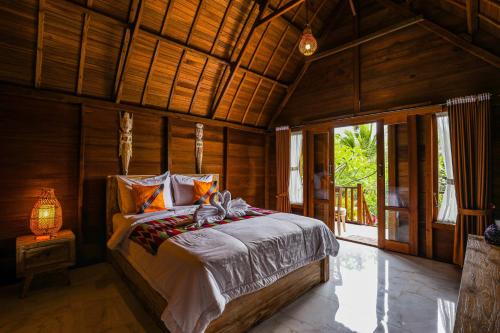 1 dormitorio con 1 cama en una habitación de madera en The Tukad Gepuh Cottage and Resto, en Nusa Penida