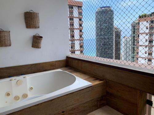 uma banheira na casa de banho com uma janela em Real Apartments 254 - Barramares flat 2 quartos de luxo com vista espetacular no Rio de Janeiro