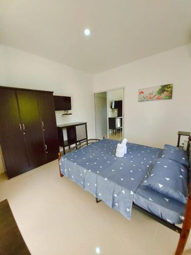 a bedroom with a large bed with blue sheets at UB HOME in Dauis