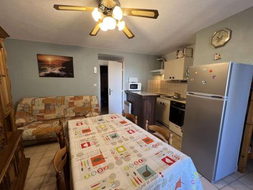 une cuisine avec une table et un réfrigérateur dans l'établissement Appartement T2 proche centre, 6 pers. avec balcon, ascenseur, à 400m de la plage et 200m des commerces - FR-1-701-38, à Valras-Plage