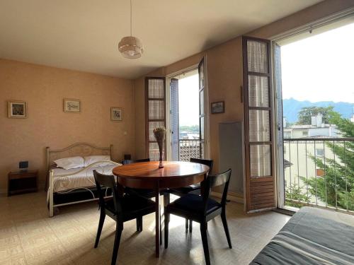 - une salle à manger avec une table, des chaises et un lit dans l'établissement Spacieux studio au centre-ville avec ascenseur et animaux acceptés - FR-1-555-79, à Aix-les-Bains