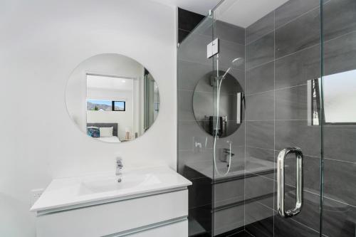 La salle de bains est pourvue d'un lavabo et d'un miroir. dans l'établissement Northlake Hideaway - Wanaka Holiday Home, à Wanaka