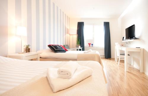 フッディンゲにあるAttendo Park Hotellのベッド2台とデスクが備わるホテルルームです。