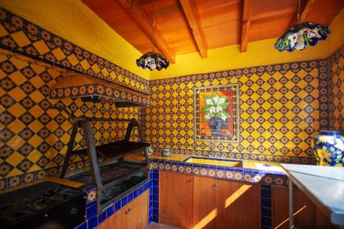- une cuisine avec des murs carrelés jaunes et bleus dans l'établissement Ex Hacienda Santa Cecilia, à Cuernavaca