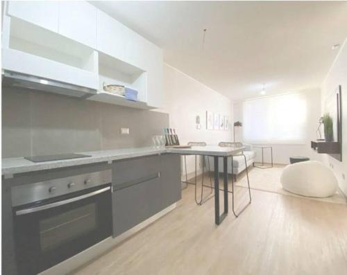 uma cozinha com um fogão e uma mesa em 408/ Precioso apartamento 1D+1B /(3 camas)/ JUMBO+CENTRO 5 MIN em Puerto Montt