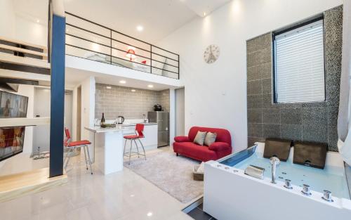 ein Wohnzimmer mit einem roten Stuhl und eine Küche in der Unterkunft Yolo Spa Pension in Gangneung