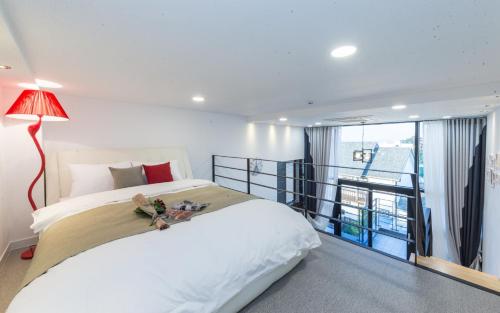 a bedroom with a large bed and a balcony at Yolo Spa Pension in Gangneung
