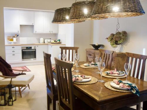 a kitchen and dining room with a wooden table and chairs at Oak Tree Cottage in Stoke Rochford