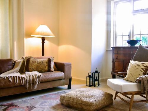 a living room with a couch and a chair at Oak Tree Cottage in Stoke Rochford