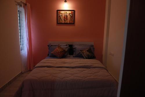 a bedroom with a bed in a red wall at AVANTI CASTELLO in Guruvāyūr
