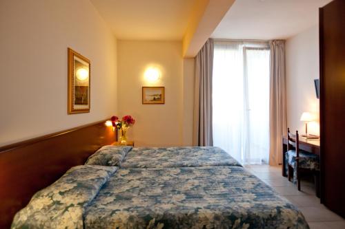 a bedroom with a bed and a window at Hotel Idania in Bardolino