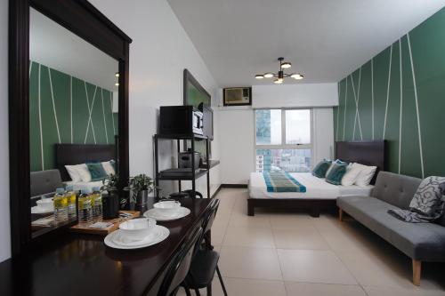 sala de estar con mesa y sofá en Millenia Suites Cozy Studio Unit 3003 en Manila