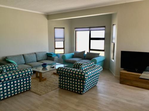a living room with couches and a flat screen tv at Ocean view, Swakopmund, 3-bedroomed apartment in Swakopmund