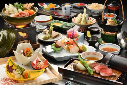 Yukemuri no Yado Inazumi Onsen في Yuzawa: طاولة مليئة بالكثير من الأنواع المختلفة من الطعام