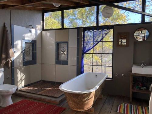 a large bathroom with a tub and a toilet at Porcupine House in Magaliesburg