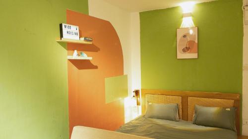 a bedroom with green and orange walls and a bed at Migo Housing 1 - Beer Street - Old Quarter in Hanoi