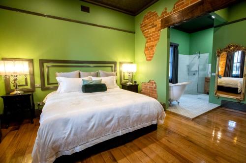 sypialnia z łóżkiem oraz łazienka z wanną w obiekcie Hotel Australasia w mieście Eden