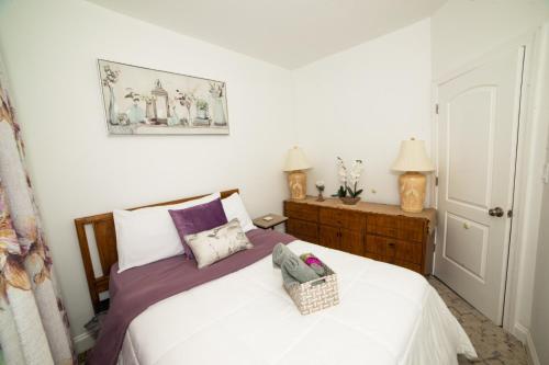 a bedroom with a white bed with a basket on it at Top Floor with Skylight Brooklyn in Brooklyn