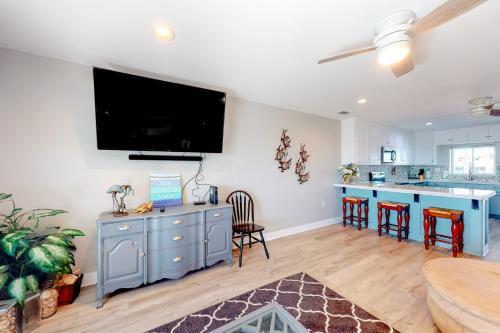 a living room with a blue cabinet and a kitchen at Isle of View Always in Mexico Beach