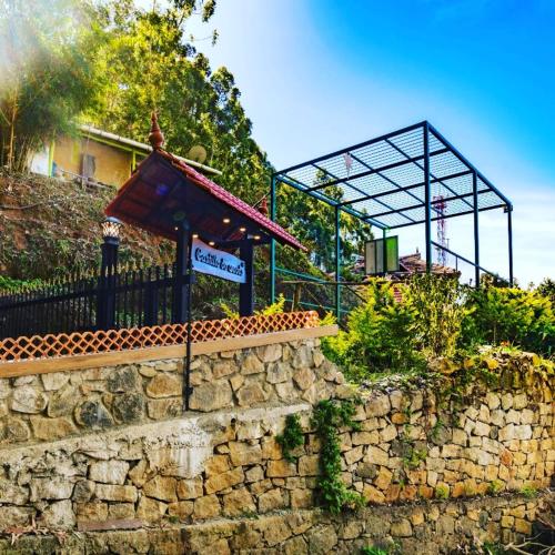 a stone wall with a sign in front of a building at Castillo De Woods , The Private Luxury Villa , 8 BHK, Vattavada in Kottakamboor