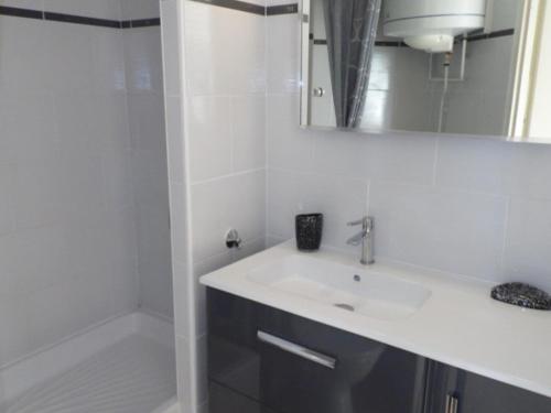 une salle de bain blanche avec un lavabo et une douche dans l'établissement Appartement 2 pièces avec mezzanine et parking privé, animaux admis - FR-1-326-405, à Marseillan