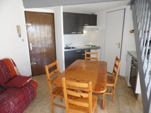 une cuisine et une salle à manger avec une table et des chaises en bois dans l'établissement Appartement 2 pièces 6 couchages, terrasse, parking privé, sud - FR-1-326-458, à Marseillan