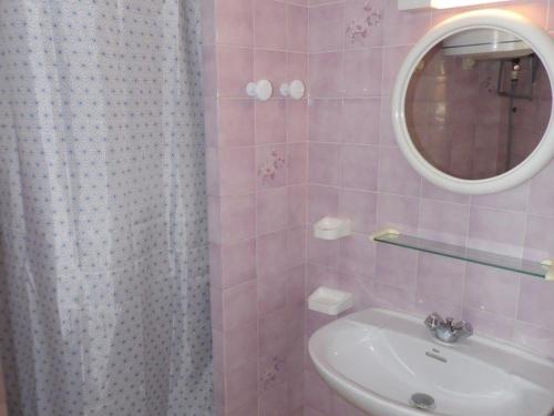 une salle de bain rose avec un lavabo et un miroir dans l'établissement Appartement 2 pièces 6 couchages, terrasse, parking privé, sud - FR-1-326-458, à Marseillan