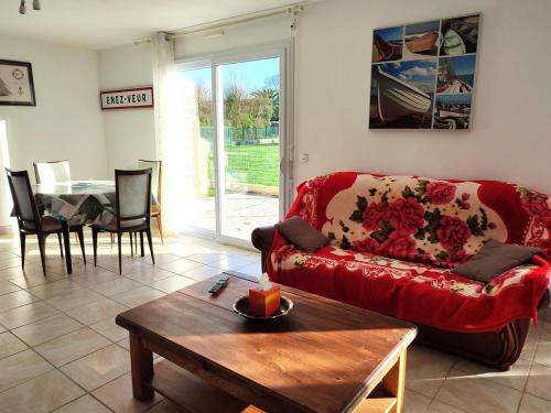 un salon avec un canapé rouge et une table dans l'établissement Maison à 210m de la plage avec jardin clos, terrasse et parking privé sur l'Île Grande - FR-1-368-214, à Pleumeur-Bodou