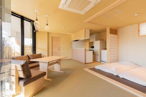 a living room with a bed and a desk in a room at 東瀛Stays 6階 ゆったり庭付きワンフロア部屋 in Osaka