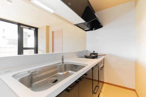 a kitchen with a sink and a large mirror at 東瀛Stays 6階 ゆったり庭付きワンフロア部屋 in Osaka