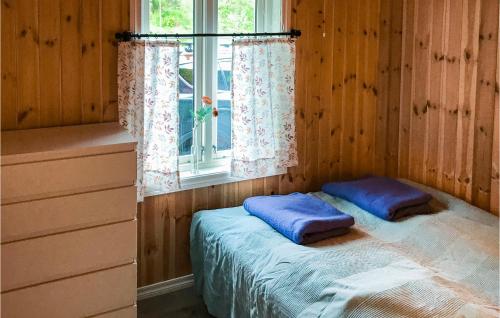 1 dormitorio con 1 cama con almohadas azules en la ventana en 1 Bedroom Gorgeous Home In Seim en Seim