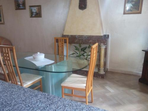 een eetkamer met een glazen tafel en stoelen bij casa Aurelia Ulassai 6 posti letto in Ulassai
