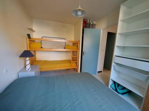 - une chambre avec un lit bleu et un placard dans l'établissement Appartement Confortable 4 pers, Terrasse, 500m Plage, Sans TV, Cuisine Équipée - FR-1-326-733, à Marseillan