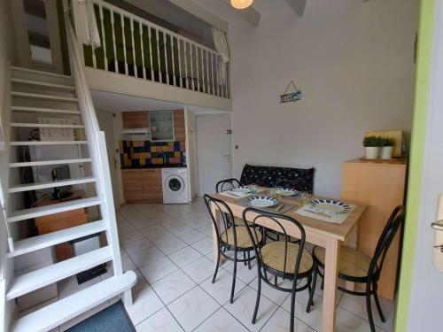 une cuisine et une salle à manger avec une table et des chaises dans l'établissement Appartement rénové 2 pièces avec mezzanine, terrasse et accès direct plage - FR-1-326-748, à Marseillan